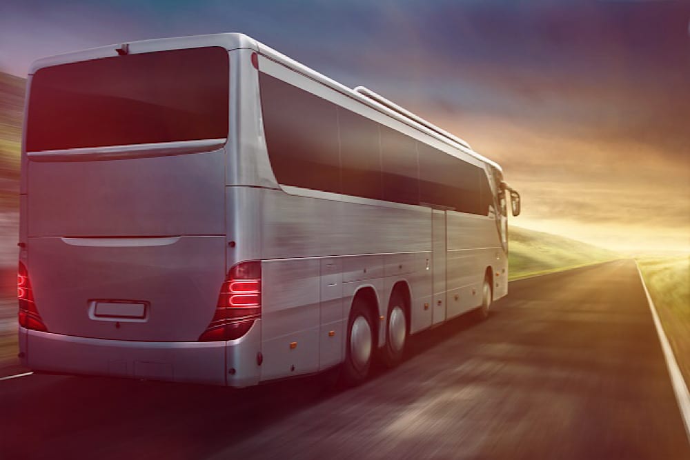 Coach driving into sunset